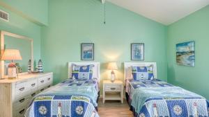 Dos camas en una habitación con paredes azules. en The Salty Aloha, en Rockport