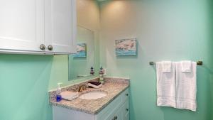 un baño con lavabo y espejo en The Salty Aloha, en Rockport