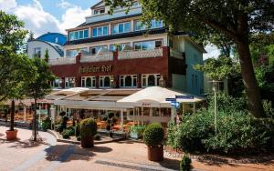 un bâtiment avec un parasol devant lui dans l'établissement Hotel Holsteiner Hof GmbH, à Timmendorfer Strand