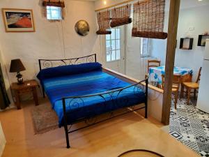 - une chambre avec un lit avec des draps bleus et une table dans l'établissement Studio 2A, à Ucciani