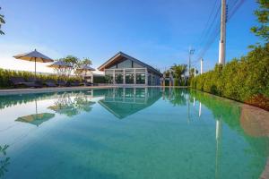 a pool of water with a house in the background at MOST Family 9 Ubon in Ubon Ratchathani