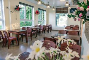 a row of tables and chairs in a room with flowers at Orchid Riverside Villa in Hue