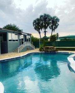 una piscina frente a una casa con palmeras en TETE PALM HOTEL en Tete