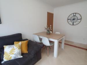 a living room with a couch and a table and a clock at Miramar in Viveiro