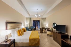 a hotel room with a bed and a desk at Al Bahar Hotel & Resort in Fujairah