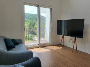 a living room with a tv and a couch and a window at SunnyVille 90 in Yangpyeong