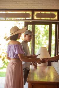 a woman in a hat and a man looking at a cell phone at Cabé Bali in Jasri