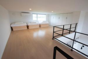 ein Zimmer mit zwei Betten und einer Treppe darin in der Unterkunft Yadoya YADOKARI 2nd in Pippu