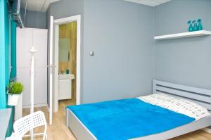 1 dormitorio azul con 1 cama y 1 silla en Hostel Filip 2, en Gdansk