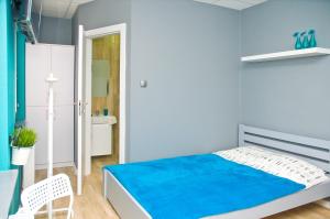 a blue bedroom with a bed and a chair at Hostel Filip 2 in Gdańsk