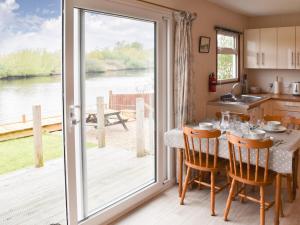 a kitchen and dining room with a table and a sliding glass door at Pintail in Brundall