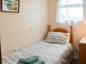 a small bedroom with a bed and a window at Pintail in Brundall