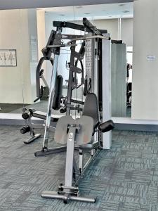 a gym with several tread machines and a chair at Binjai 8 KLCC by PSM Luxury Suites in Kuala Lumpur