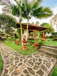 a stone walkway in front of a house with palm trees at Cabé Bali in Jasri