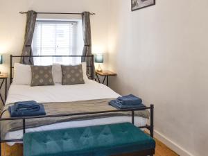 a bedroom with a bed with a metal bed frame and a window at Tryfar House in Harlech