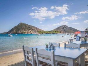 a view of the beach with tables and chairs at Studio στο Τολό in Tolo