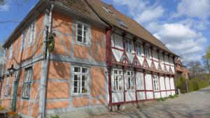 stary drewniany budynek z bieli i czerwieni w obiekcie Klosterkrug Apartments w mieście Lüneburg