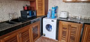 a kitchen with a washing machine and a sink at OKF OBOUBA APARTMENT in Kumasi