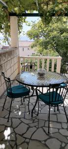 un tavolo e delle sedie seduti su un patio di Apartment in Bol with sea view, terrace, air conditioning,WiFi 3634-2 a Bol