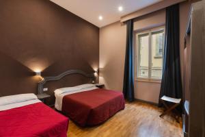 a hotel room with two beds and a window at Hotel Unicorno in Florence