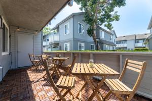 a patio with four chairs and a wooden table at "INACTIVE UNBOOKABLE - 5 mins from Disneyland and Convention Center - Your Perfect SoCal Getaway!" in Anaheim