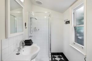 uma casa de banho branca com um lavatório e um chuveiro em Birches em Mansfield