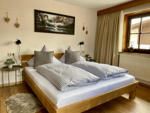 a bedroom with a bed with white sheets and a window at Haus Tirol Ehrwald in Ehrwald