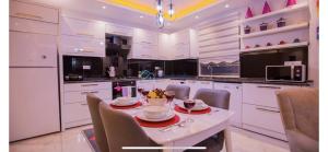 eine Küche mit weißen Schränken sowie einem Tisch und Stühlen in der Unterkunft Villa flamingo in Kaş