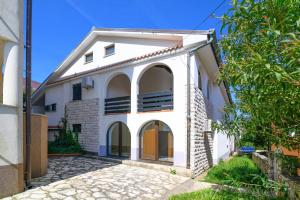 a white house with arched windows at Apartment Premantura 2228a in Premantura