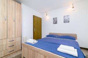 a bedroom with a blue bed with a wooden cabinet at Apartment Premantura 2228a in Premantura