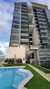 a building with a swimming pool in front of a building at Andromeda Seaview Condo Near Beach in Pattaya South