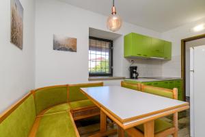 a kitchen with green cabinets and a table and chairs at Apartment Premantura 2228a in Premantura