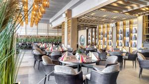 restauracja ze stołami, krzesłami i roślinami w obiekcie DIT Majestic Beach Resort w Słonecznym Brzegu