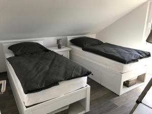 2 camas blancas en una habitación con faldas en Ferienhaus Oskar 100m Entfernung zum See/Strand, en Löbnitz