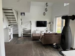 ein Wohnzimmer mit Couch und Fernseher in der Unterkunft Ferienhaus Oskar 100m Entfernung zum See/Strand in Löbnitz