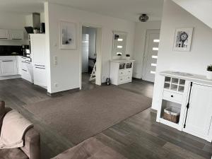 sala de estar con armarios blancos y alfombra en Ferienhaus Oskar 100m Entfernung zum See/Strand, en Löbnitz