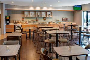 a restaurant with tables and chairs and a kitchen at SpringHill Suites St. Louis Brentwood in Brentwood