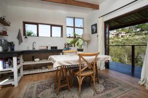 a kitchen with a table and chairs in a room at Forest Studio in Knysna