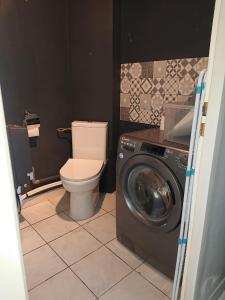 a bathroom with a toilet and a washing machine at chambre privée à BORDEAUX PELLEGRIN in Bordeaux