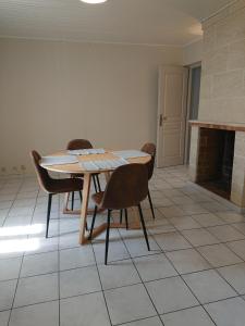 uma mesa e cadeiras num quarto com lareira em chambre privée à BORDEAUX PELLEGRIN em Bordeaux