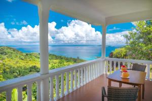a porch with a view of the ocean at Maison Du Soleil Self Catering in Anse Possession