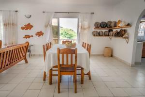 a dining room with a table and chairs and a window at Maison Du Soleil Self Catering in Anse Possession