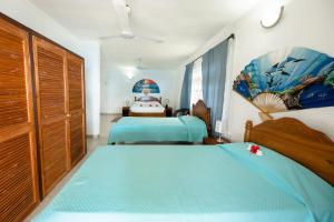 a bedroom with two twin beds and a large window at Maison Du Soleil Self Catering in Anse Possession