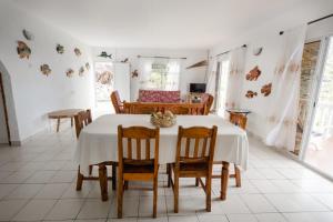 a dining room with a white table and chairs at Maison Du Soleil Self Catering in Anse Possession