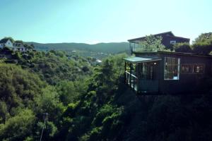 a house on the side of a hill with trees at Forest Studio in Knysna +22 photos
