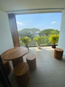 a balcony with a table and stools in front of a window at Bann Chidtha family suite full kitchen near Suvarnabhumi Airport in Bangkok