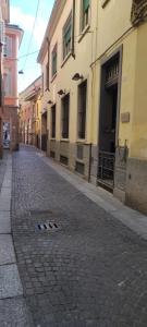una strada di ciottoli in una città con edifici di Palazzo Altavilla Deluxe a Parma