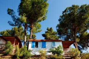 dom w lesie z drzewami w tle w obiekcie Camping Village Rosselba Le Palme w mieście Portoferraio