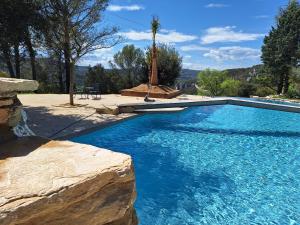 a swimming pool with blue water in a yard at Hôtel restaurant Clos des Sullys in Montclus