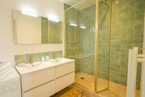 uma casa de banho com um lavatório e uma cabina de duche em vidro. em Hyper centre - duplex 73m2 au dernier étage em Le Touquet-Paris-Plage